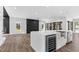 Spacious kitchen island with stainless steel appliances, including a wine fridge, and a view of the fireplace at 73 Clyde Pearce Rd, Zebulon, NC 27597