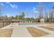 Community pool surrounded by lounge chairs, a black fence, and a clear sky at 73 Clyde Pearce Rd, Zebulon, NC 27597