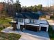 Aerial view of modern home with two-car garage, roof, large driveway, and manicured lawn at 73 Clyde Pearce Rd, Zebulon, NC 27597