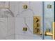 Shower's gold fixtures and controls stand out against marble tiled wall at 73 Clyde Pearce Rd, Zebulon, NC 27597