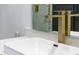 Close-up of a modern white sink with gold faucet and vanity mirror in the bathroom at 73 Clyde Pearce Rd, Zebulon, NC 27597