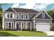 Charming home featuring a two-car garage, covered porch, and a harmonious blend of colors and architectural details at 740 Portland Rose Dr, Knightdale, NC 27545