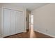 Bright bedroom featuring hardwood floors and a closet with louvered doors at 815 Riverbark Ln, Durham, NC 27703