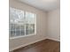 Bright, empty bedroom with a large window and hardwood floors at 815 Riverbark Ln, Durham, NC 27703