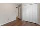 Bedroom featuring hardwood floors and a closet with louvered doors at 815 Riverbark Ln, Durham, NC 27703