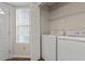 Convenient laundry room features a washer, dryer, and shelving for storage at 815 Riverbark Ln, Durham, NC 27703