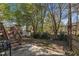 Backyard featuring a wooden deck with steps, a patio with a grill, a storage shed and mature trees at 9512 Anson Grove Ln, Raleigh, NC 27615