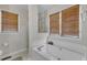 Relaxing bathroom showcasing a large soaking tub, wooden blinds, and neutral tile flooring at 9512 Anson Grove Ln, Raleigh, NC 27615