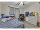 Comfortable bedroom featuring wood-look floors, a ceiling fan, and a window with gray curtains at 9512 Anson Grove Ln, Raleigh, NC 27615