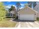 Charming, single-story home with a two-car garage, manicured lawn and sidewalk to the front door at 9512 Anson Grove Ln, Raleigh, NC 27615