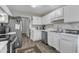 The kitchen features stainless steel appliances, white cabinets, and a doorway to a hallway, creating a functional space at 9512 Anson Grove Ln, Raleigh, NC 27615
