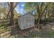 Outdoor storage shed with double doors, surrounded by mature trees in a well maintained backyard at 9512 Anson Grove Ln, Raleigh, NC 27615