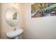 Half bathroom featuring a pedestal sink, oval mirror, and nature-themed decorations at 1 Serenity Ct, Durham, NC 27704