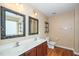 Bathroom featuring a double sink vanity, two decorative mirrors, and wood-look flooring at 1 Serenity Ct, Durham, NC 27704