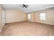 Large, carpeted bedroom with two windows providing natural light and a ceiling fan at 1 Serenity Ct, Durham, NC 27704