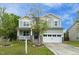 Charming two-story home featuring a covered front porch, stone accents, and an attached two-car garage at 1 Serenity Ct, Durham, NC 27704