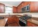 Kitchen showcasing stainless steel appliances, dark countertops, and dark wood cabinets at 1 Serenity Ct, Durham, NC 27704