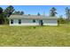 Back exterior with a grill and a spacious green lawn at 10 Chaney Ln, Louisburg, NC 27549