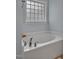 Bright bathroom with a soaking tub illuminated by unique glass block window at 100 Hillside Village Dr, Louisburg, NC 27549