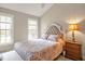 Bedroom with vaulted ceiling, neutral walls, patterned bedding and natural light at 100 Hillside Village Dr, Louisburg, NC 27549