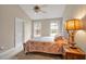 Cozy bedroom featuring vaulted ceiling, neutral walls, patterned bedding and natural light at 100 Hillside Village Dr, Louisburg, NC 27549