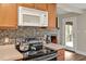 Close up of kitchen with stainless steel appliances, mosaic backsplash and tile countertops at 100 Hillside Village Dr, Louisburg, NC 27549