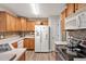 Spacious kitchen featuring wood cabinets, stainless steel appliances, and tile backsplash at 100 Hillside Village Dr, Louisburg, NC 27549
