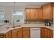 Traditional kitchen featuring stainless steel sink, wooden cabinetry and mosaic tile backsplash at 100 Hillside Village Dr, Louisburg, NC 27549