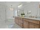 Luxurious bathroom featuring a soaking tub, double vanity, and elegant chandelier at 1009 High Trail Ct, Wake Forest, NC 27587