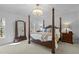 Bright bedroom with a four-poster bed, chandelier, and natural light at 1009 High Trail Ct, Wake Forest, NC 27587