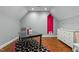 Bonus room with hardwood floors, a black desk, white dresser and an accent pink alcove at 1009 High Trail Ct, Wake Forest, NC 27587
