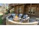 Outdoor patio area featuring a cozy fire pit with a stone surround and scenic backyard views at 1009 High Trail Ct, Wake Forest, NC 27587