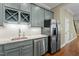 Kitchenette features stainless steel appliances and stylish blue-gray cabinetry at 1009 High Trail Ct, Wake Forest, NC 27587