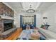 Elegant living room featuring a stone fireplace, hardwood floors, bright windows, and stylish decor at 1009 High Trail Ct, Wake Forest, NC 27587