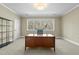 Spacious office with large window, neutral colored walls, carpet and a wooden desk with a tufted chair at 1009 High Trail Ct, Wake Forest, NC 27587