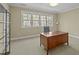 Office space featuring a large desk with a chair facing a bright window and neutral colored walls at 1009 High Trail Ct, Wake Forest, NC 27587