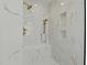 Elegant shower with marble tile, bench seat, and gold fixtures at 1009 High Trail Ct, Wake Forest, NC 27587