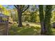 Spacious backyard with mature trees, white picket fence, picnic table, and serene natural surroundings at 1188 Turner Rd, Creedmoor, NC 27522