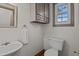 Quaint powder room features a pedestal sink, toilet, and a charming window at 1188 Turner Rd, Creedmoor, NC 27522