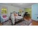 Bedroom with many windows has wood flooring, area rug and is brightly lit at 1188 Turner Rd, Creedmoor, NC 27522