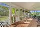 Charming screened porch with brick flooring, hanging plants, and wrought iron furniture for relaxing outdoors at 1188 Turner Rd, Creedmoor, NC 27522