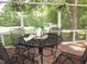 The screened porch is perfect for entertaining with views of the landscaped yard and white hanging flower baskets at 1188 Turner Rd, Creedmoor, NC 27522