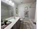 Well-lit bathroom featuring a modern vanity, a large mirror, and a combination of tub and shower at 1208 Wind Rose Dr, Fuquay Varina, NC 27526