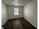 Bedroom featuring a light fixture, a window and dark wood flooring at 1208 Wind Rose Dr, Fuquay Varina, NC 27526