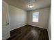 Bedroom featuring a light fixture, a window and dark wood flooring at 1208 Wind Rose Dr, Fuquay Varina, NC 27526