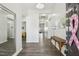 Inviting foyer featuring hardwood floors, modern lighting, and a glimpse into the open-concept living spaces at 1208 Wind Rose Dr, Fuquay Varina, NC 27526