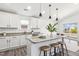 Bright kitchen with white cabinets, granite countertops, an island with bar seating, and modern pendant lighting at 1208 Wind Rose Dr, Fuquay Varina, NC 27526