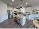 Spacious kitchen with stainless steel appliances, white cabinets, granite counters, and an island with bar stools at 1208 Wind Rose Dr, Fuquay Varina, NC 27526