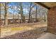 Property backyard with mature trees and fallen leaves as seen from covered porch at 1283 Schaub Dr # B, Raleigh, NC 27606
