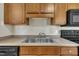 Kitchen features a double basin sink, wood cabinets, and countertop space at 1283 Schaub Dr # B, Raleigh, NC 27606